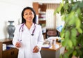 Woman doctor wear white medical uniform and stethoscope look at camera posing in clinic