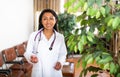 Woman doctor wear white medical uniform and stethoscope look at camera posing in clinic