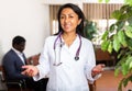 Woman doctor wear white medical uniform and stethoscope look at camera posing in clinic