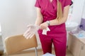 Woman doctor wearing medical sterille gloves. Selective focus on hands. Modern clinic interior in the background. Royalty Free Stock Photo