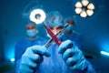 Woman doctor wearing uniform and gloves making x sign with scalpels in surgery Royalty Free Stock Photo