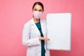 Woman doctor wearing a white medical coat and a mask holding blank board with copy space for text isolated on background Royalty Free Stock Photo