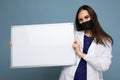 Woman doctor wearing a white medical coat and a mask holding blank board with copy space for text isolated on background Royalty Free Stock Photo