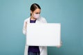 Woman doctor wearing a white medical coat and a mask holding blank board with copy space for text isolated on background Royalty Free Stock Photo