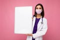 Woman doctor wearing a white medical coat and a mask holding blank board with copy space for text isolated on background Royalty Free Stock Photo