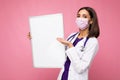 Woman doctor wearing a white medical coat and a mask holding blank board with copy space for text isolated on background Royalty Free Stock Photo