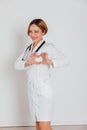woman doctor in white coat with phonendoscope shows heart Royalty Free Stock Photo