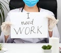 Woman doctor in a white coat, sterile medical gloves holds a poster with the inscription I need work Royalty Free Stock Photo