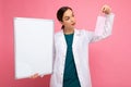 Woman doctor in a white medical coat holding blank board with copy space for text and protective mask isolated on Royalty Free Stock Photo