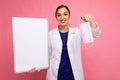 Woman doctor in a white medical coat holding blank board with copy space for text and protective mask isolated on Royalty Free Stock Photo