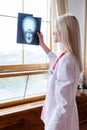 Woman doctor at window looking at skull scan Royalty Free Stock Photo