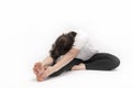 Woman does gymnastics and performs an exercise to develop flexibility. Portrait of girl practicing yoga on white background Royalty Free Stock Photo