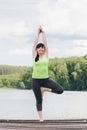 Woman does yoga on the bridge in the summer Royalty Free Stock Photo