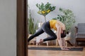 woman does yoga and meditation at home rug in cozy apartment. lady is engaged in physical exercises Royalty Free Stock Photo