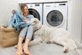 Woman with a dog doing housework in the laundry Royalty Free Stock Photo