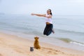 Woman and dog enjioy morning on beach