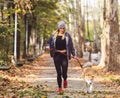 Woman and dog jogging in the park. Healthy lifestyle