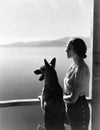 Woman And Dog Looking Out Over Water
