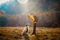 woman and dog outdoors in autumn sunrise social distancing