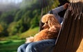 Woman with dog resting on the hanging chair on the terrace mountain chalet.