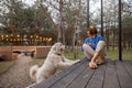 Woman with dog rests near wooden cottage in nature Royalty Free Stock Photo