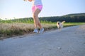 Woman with a dog running down a gravel street Royalty Free Stock Photo