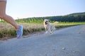 Woman with a dog running down a gravel street Royalty Free Stock Photo