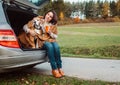 Woman with dog sit together in cat truck and warms hot tea Royalty Free Stock Photo