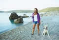 Woman with a dog on a walk on the beach Royalty Free Stock Photo