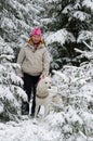 Woman with a dog on walk in a winter wood Royalty Free Stock Photo