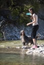 Woman and dog walking in water