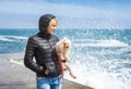 Woman with a doggie of in the early spring near the sea Royalty Free Stock Photo