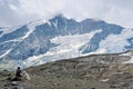 Woman and dogs sitting at path to Grossglockner Mountain and Pa