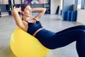 Woman doing abdominal crunches pilates exercise on exercise fitness ball at gym. Exercises for the abs. Swiss ball Royalty Free Stock Photo