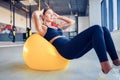 Woman doing abdominal crunches pilates exercise on exercise fitness ball at gym. Exercises for the abs. Swiss ball Royalty Free Stock Photo