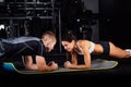 Woman doing abdominal crunches press exercise on the mat with her sports male trainer. Royalty Free Stock Photo