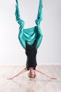 Woman doing aerial yoga upside down on head