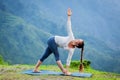 Woman doing Ashtanga Vinyasa yoga asana Parivrtta trikonasana