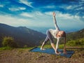 Woman doing Ashtanga Vinyasa yoga asana Parivrtta trikonasana