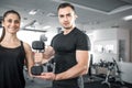 Woman doing bicep curls in gym with her personal trainer Royalty Free Stock Photo