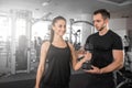 Woman doing bicep curls in gym with her personal trainer Royalty Free Stock Photo