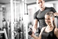 Woman doing bicep curls in gym with her personal trainer Royalty Free Stock Photo