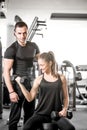 Woman doing bicep curls in gym with her personal trainer Royalty Free Stock Photo