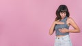 Woman doing a Breast Self-Exam over pink background.