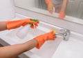 Woman doing chores in bathroom at home, cleaning sink and faucet Royalty Free Stock Photo