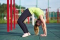 Woman doing exercise bridge. Stretching danser or gymnast training trains in workout sports ground.