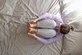 Woman doing exercise for spine on bed, lying in Knees to Chest pose Royalty Free Stock Photo