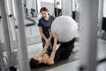 Woman doing exercises with fitness ball with rehabilitation specialist at the gym Royalty Free Stock Photo