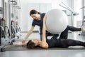 Woman doing exercises with fitness ball with rehabilitation specialist at the gym Royalty Free Stock Photo
