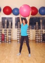 Woman doing exercises with pink fit ball in fitness gym class. Fitness ball helps women get a toned, tight stomach and strong core Royalty Free Stock Photo